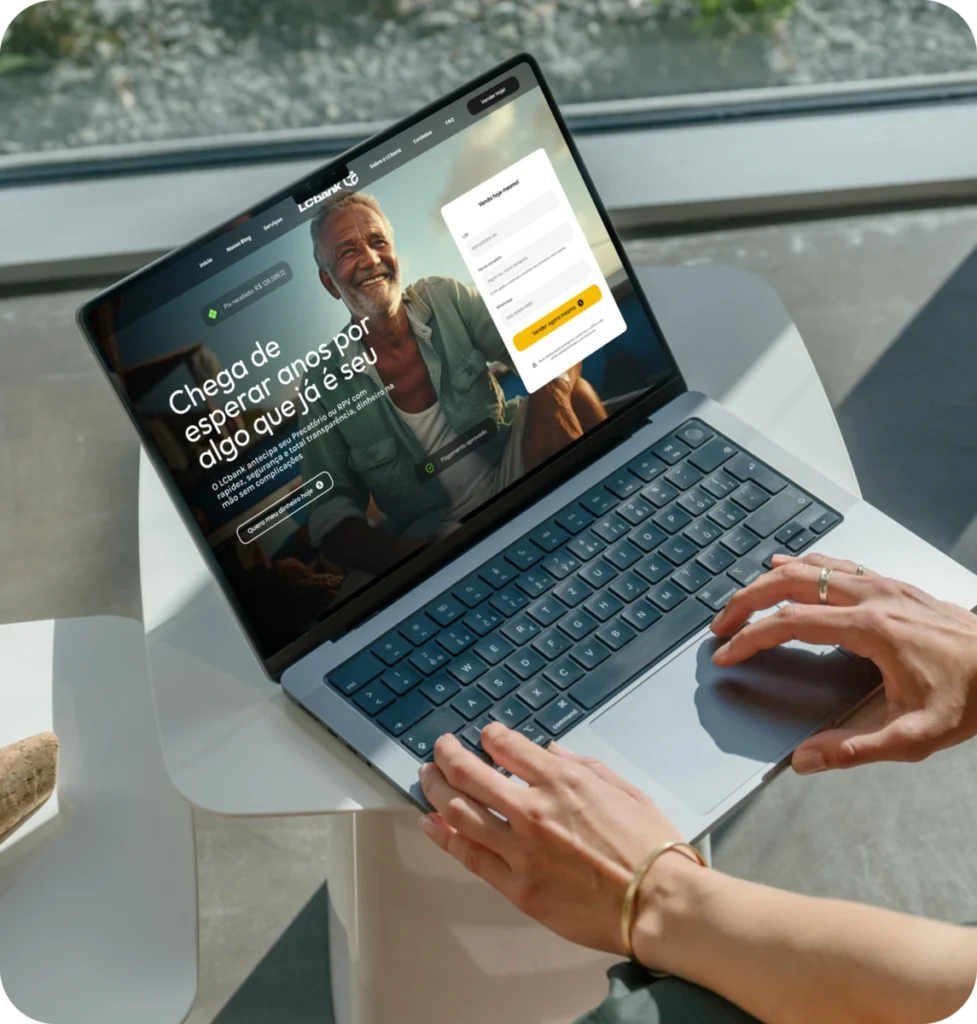 Laptop aberto exibindo site do LG Bank com texto "Chega de esperar por algo que já é seu